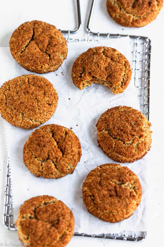 Gluten Free snickerdoodles on a cooling rack with a bite taken out of one