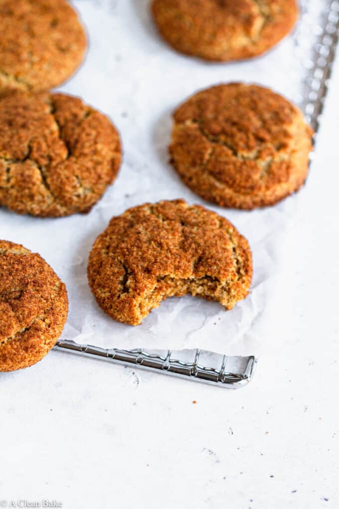 Gluten Free snickerdoodles on a cooling rack with a bite taken out of one