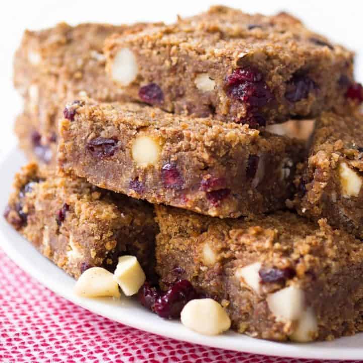 Gooey and decadent cranberry white chocolate macadamia nut blondies. Perfect for Valentine's Day, don't you think? (gluten free, paleo friendly, naturally sweetened, low carb)