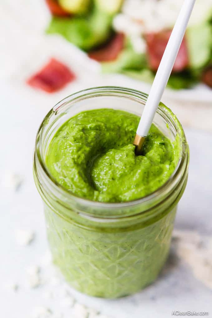 Green goddess salad dressing in a jar with a spoon