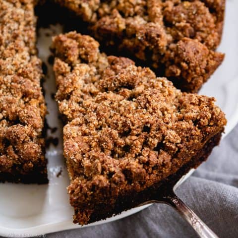 Spatula serving piece of paleo blueberry crumb cake - square