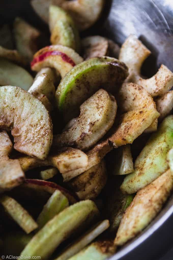 Peeled and sliced apples covered in cinnamon for vegan paleo apple crisp