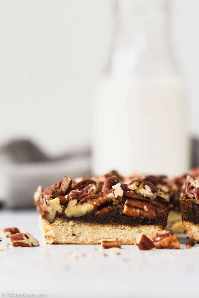 gluten free and paleo pecan pie bar on a table with a glass of milk