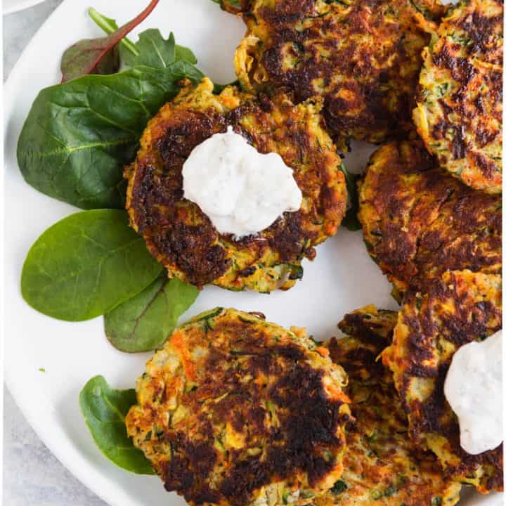 Paleo gluten free vegetable fritter with yogurt sauce on a plate