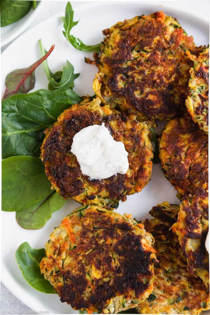 Paleo gluten free vegetable fritter with yogurt sauce on a plate