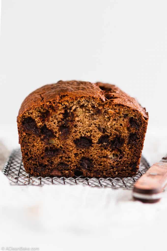 Loaf of paleo gluten free banana bread on a cooling rack with a knife