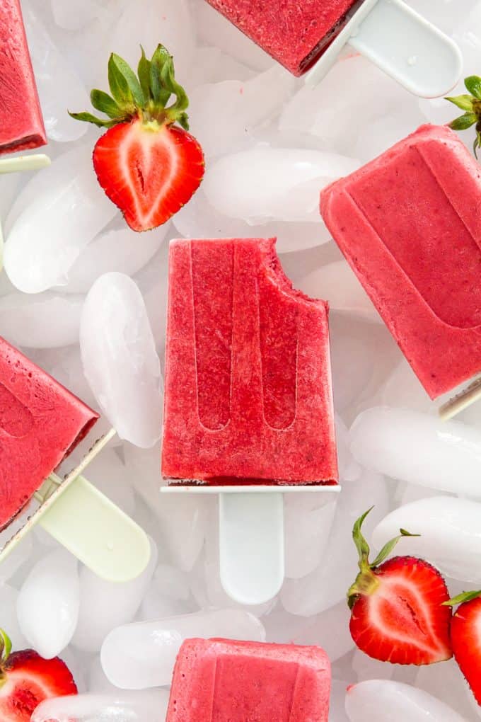 Tray of Strawberries and Cream Popsicles (gluten free, paleo, vegan, and naturally sweetened) with ice and fresh strawberries