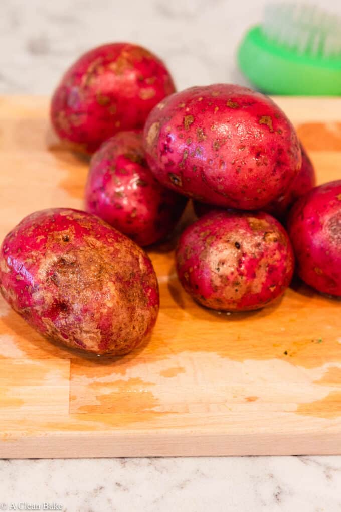 pile of washed potatoes on a cutting board