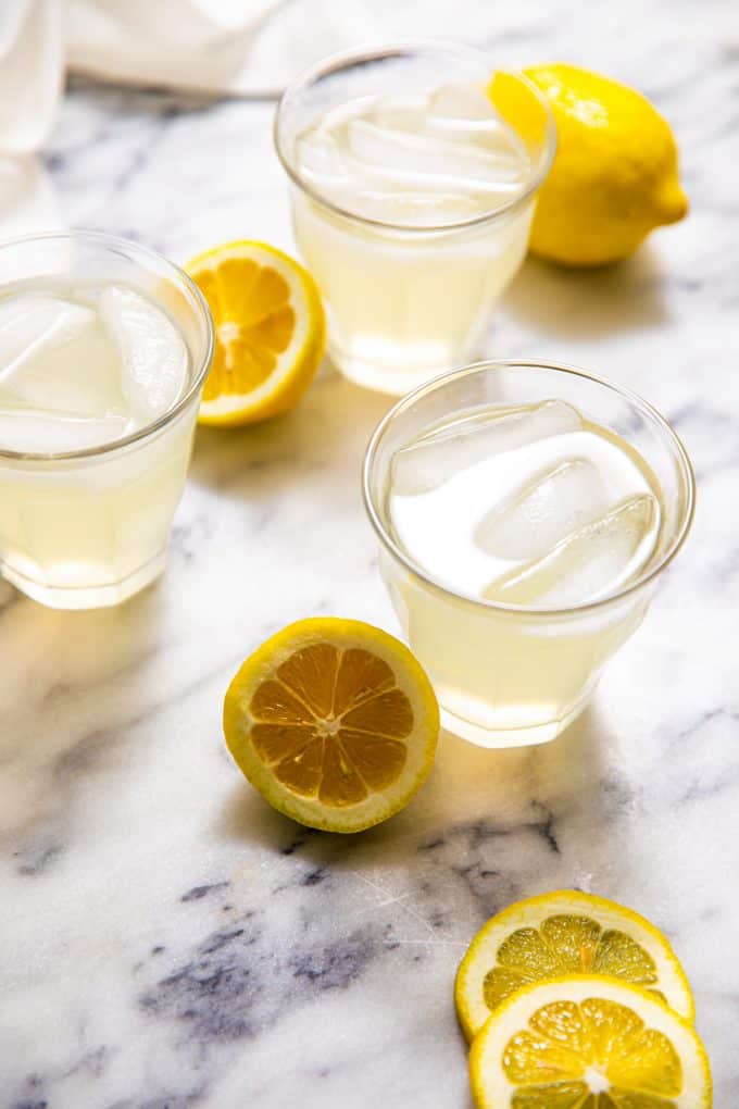 Three glasses of Sugar Free Lemonade surrounded by lemons