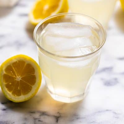 Glass of Sugar Free Lemonade surrounded by lemons