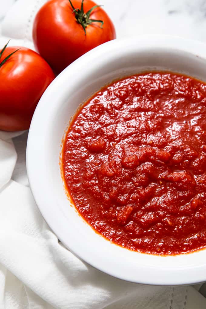 Close up of pizza sauce in a white bowl