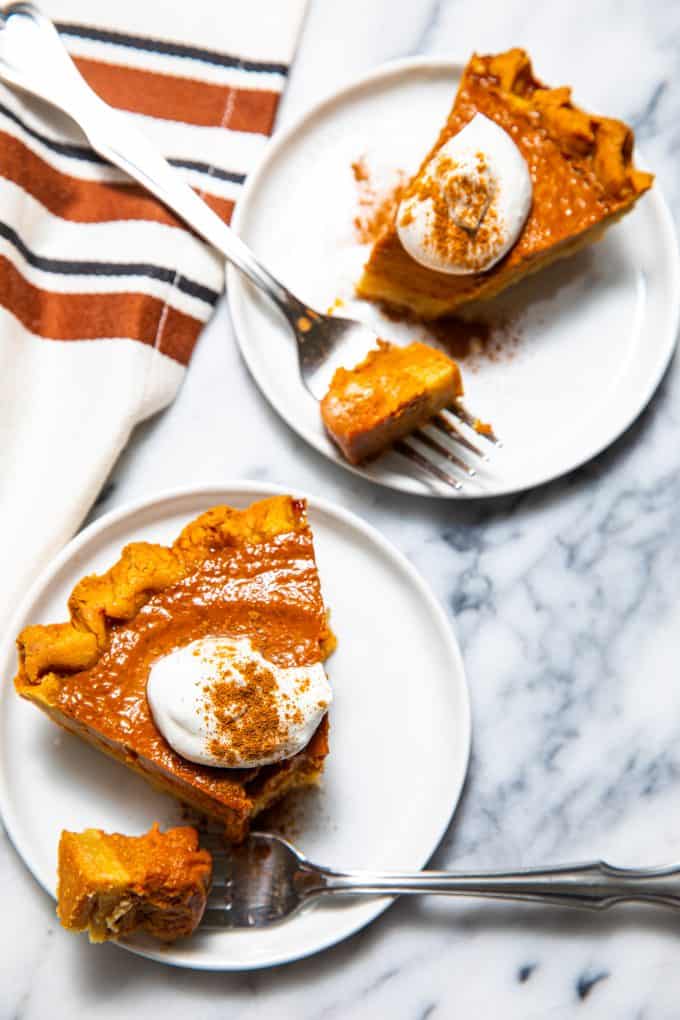 Slices of paleo gluten free pumpkin pie on plates with forks