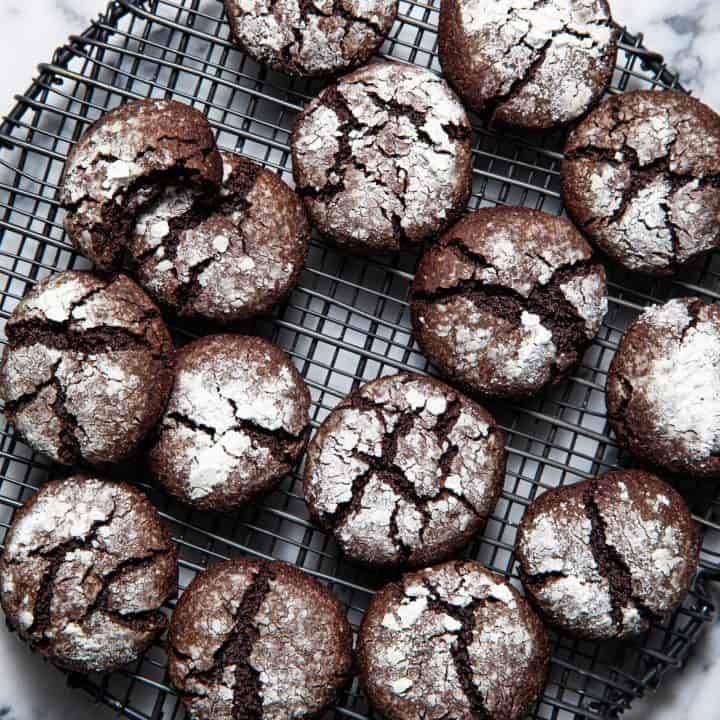 Array of Paleo gluten free chocolate crinkle cookies on a round wire rack